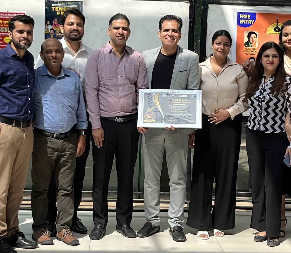 Colleagues gathered around a framed certificate at the office