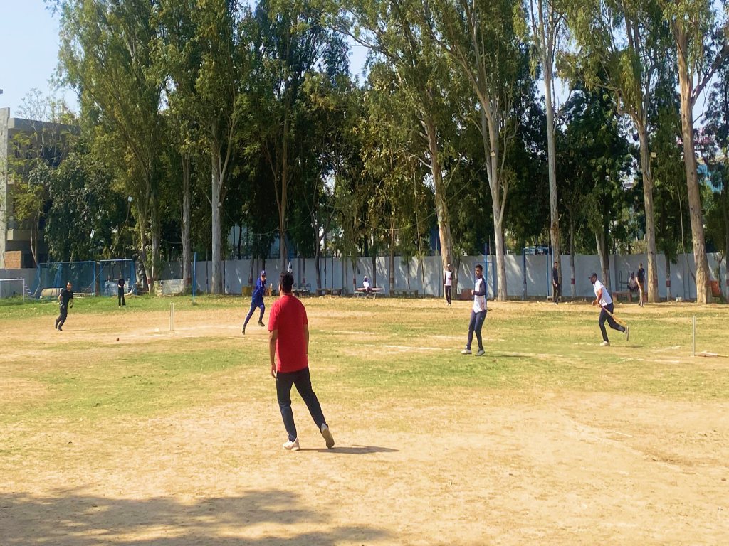TBI team playing a cricket match on an open ground